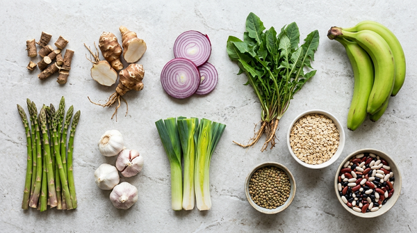 Best prebiotic foods including chicory root, Jerusalem artichoke, garlic, onion, leeks, asparagus, green bananas, oats, beans, lentils, and dandelion greens.